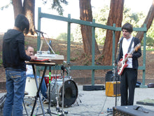 Load image into Gallery viewer, Three musicians playing instruments outdoors with trees in the background, Mosswood Park, Oakland. Photo by George Chen