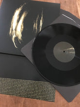Load image into Gallery viewer, Black vinyl record partially removed from sleeve with abstract gold brushstroke design on black album cover and dense gold.